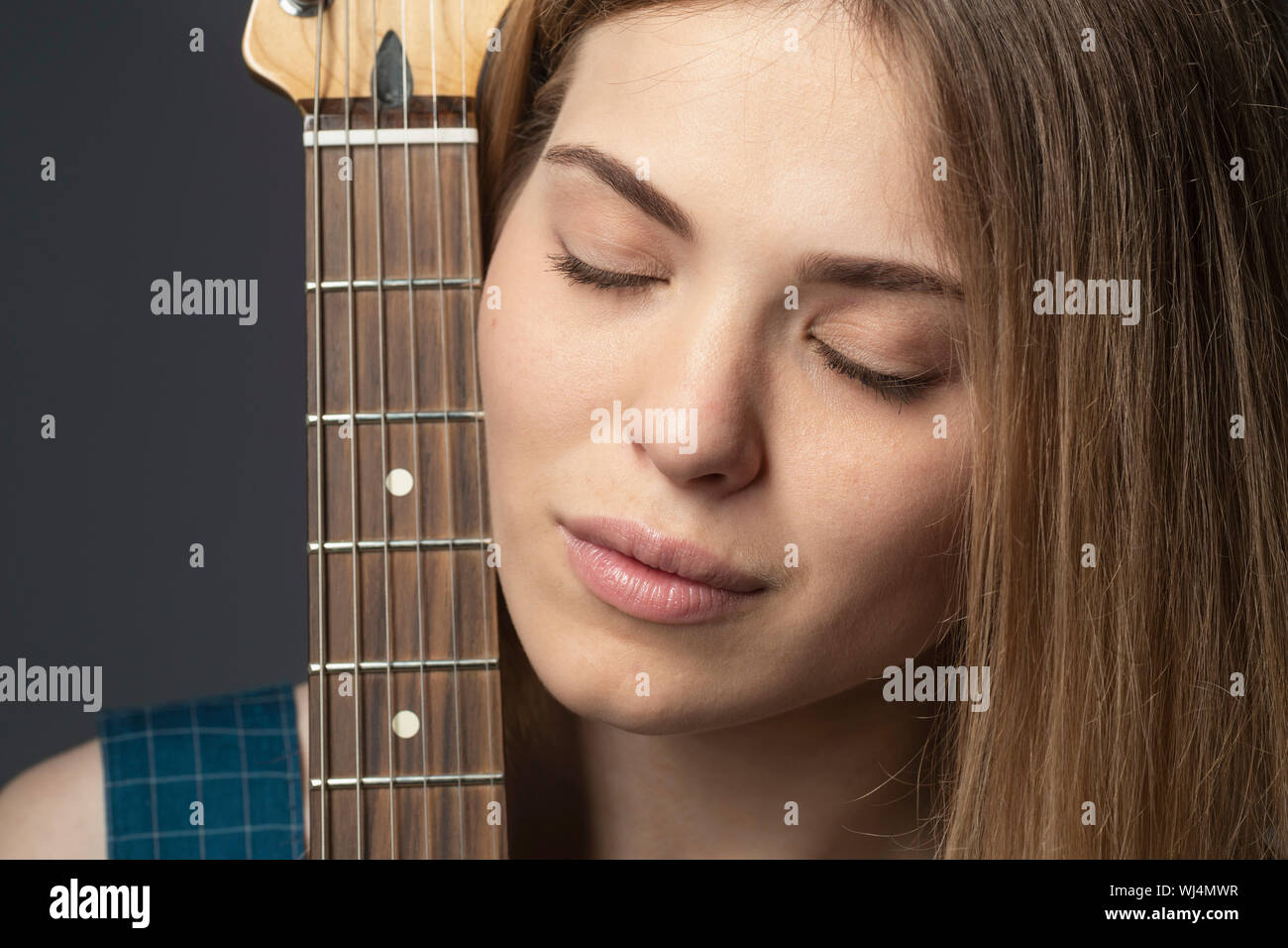 Close up ritratto sereno giovane donna con la chitarra Foto Stock