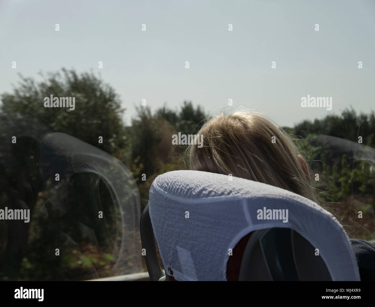 Donna sul treno, rilassante guardando fuori della finestra di sole Foto Stock