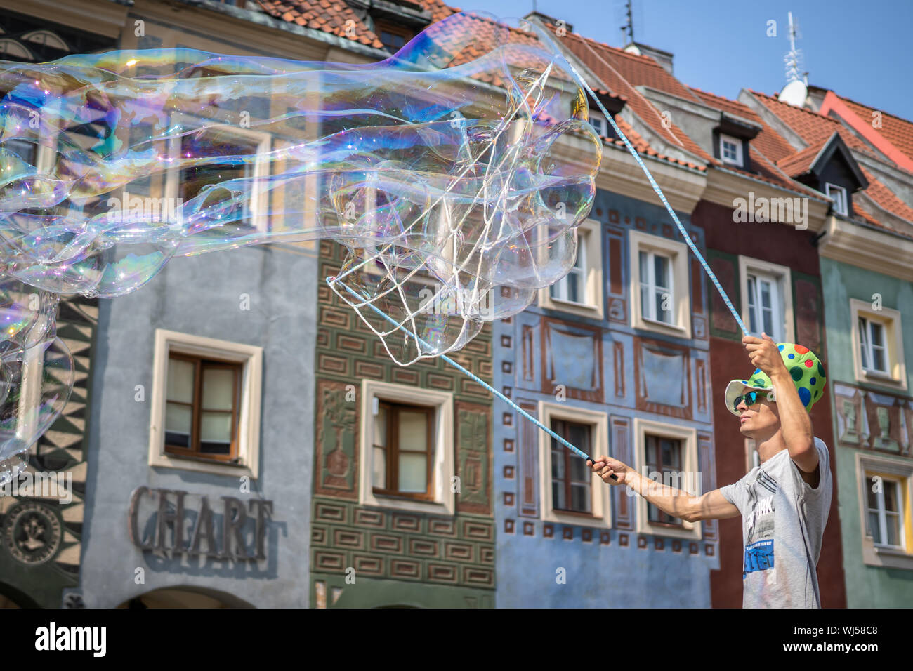 Un uomo di eseguire, soffiando grandi bolle a Piazza della Città Vecchia. Foto Stock