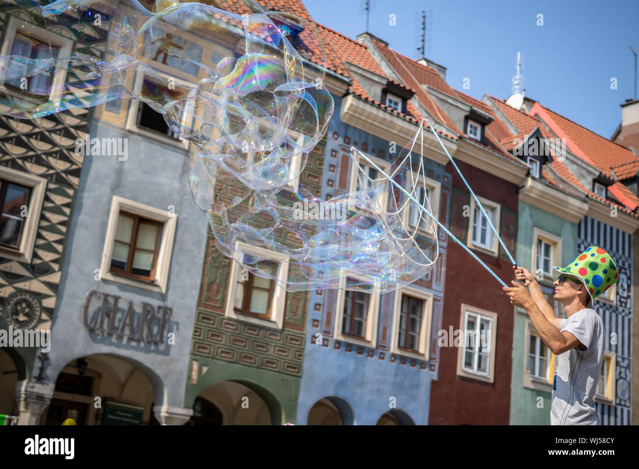 Un uomo di eseguire, soffiando grandi bolle a Piazza della Città Vecchia. Foto Stock