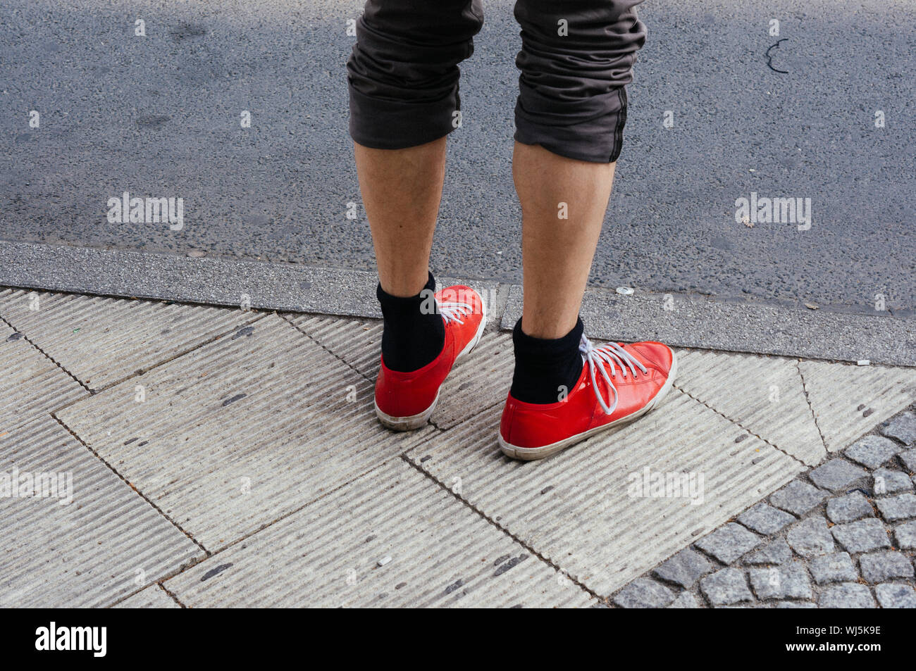 Close up delle gambe di un uomo in piedi sul marciapiede Foto Stock