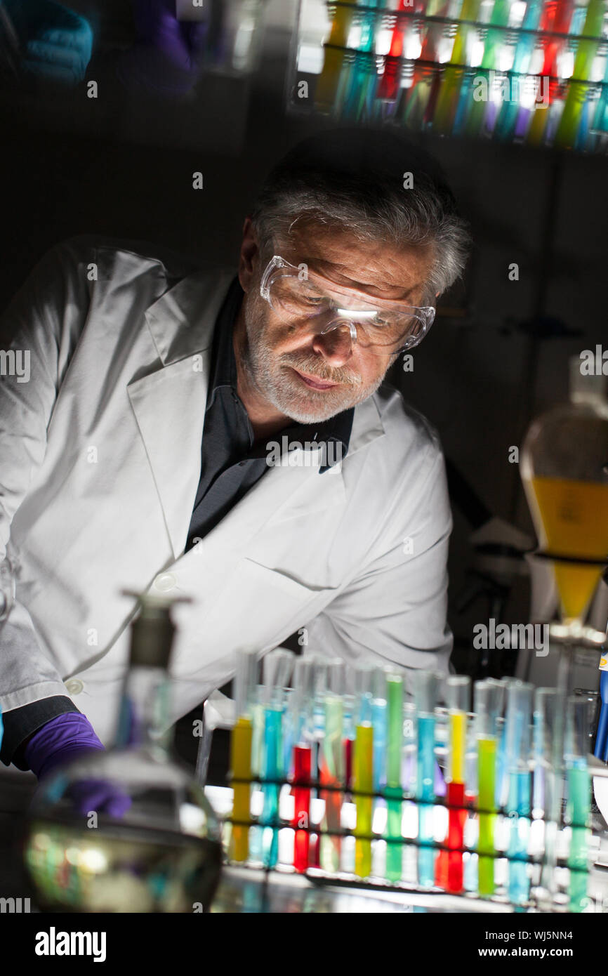 Senior chimico maschio lavora fino a tardi in Science Research Laboratory (chimica analitica, organica, strutturale, Biochimica, Genetica, forensics, Foto Stock
