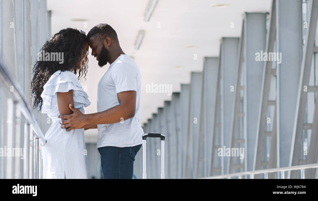 African American giovane cuddling in aeroporto prima della partenza del volo Foto Stock