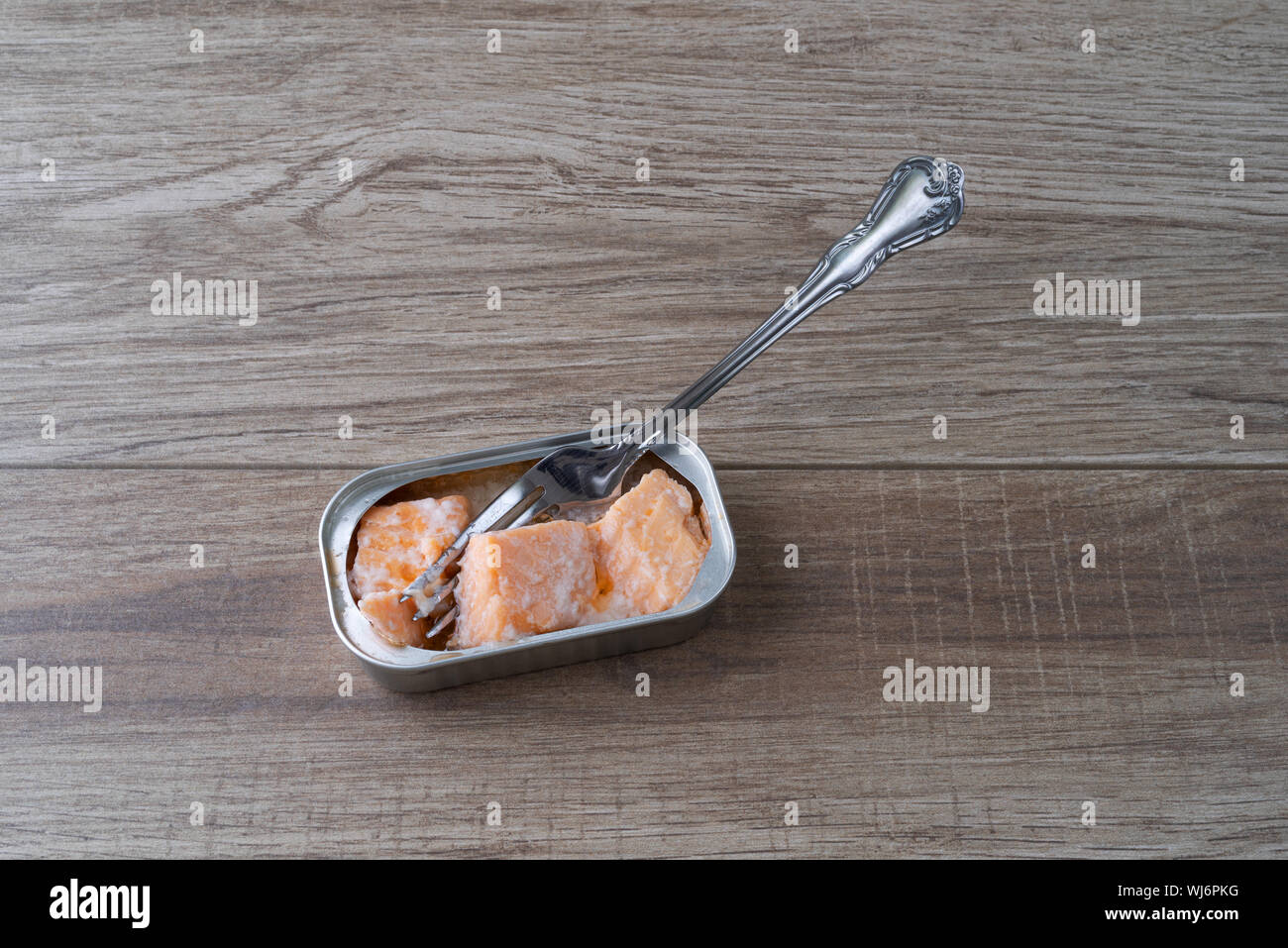 Aprire lo stagno di salmone in acqua con una forchetta in il cibo sul bancone. Foto Stock