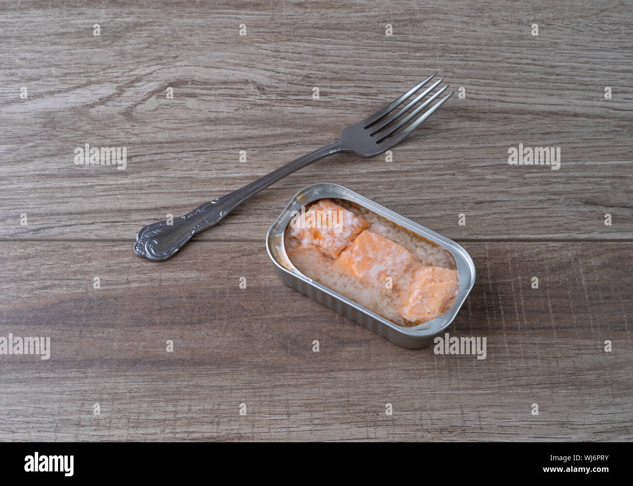 Aprire lo stagno di salmone in acqua con una forcella per il lato sul bancone illuminato con luce naturale. Foto Stock
