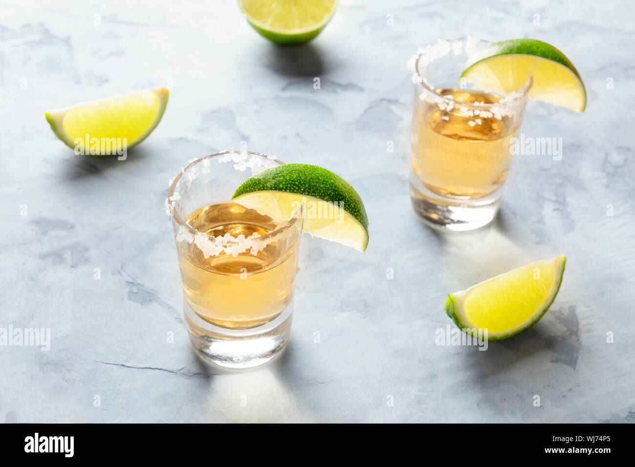 Golden tequila scatti con fettine di lime e sale Foto Stock