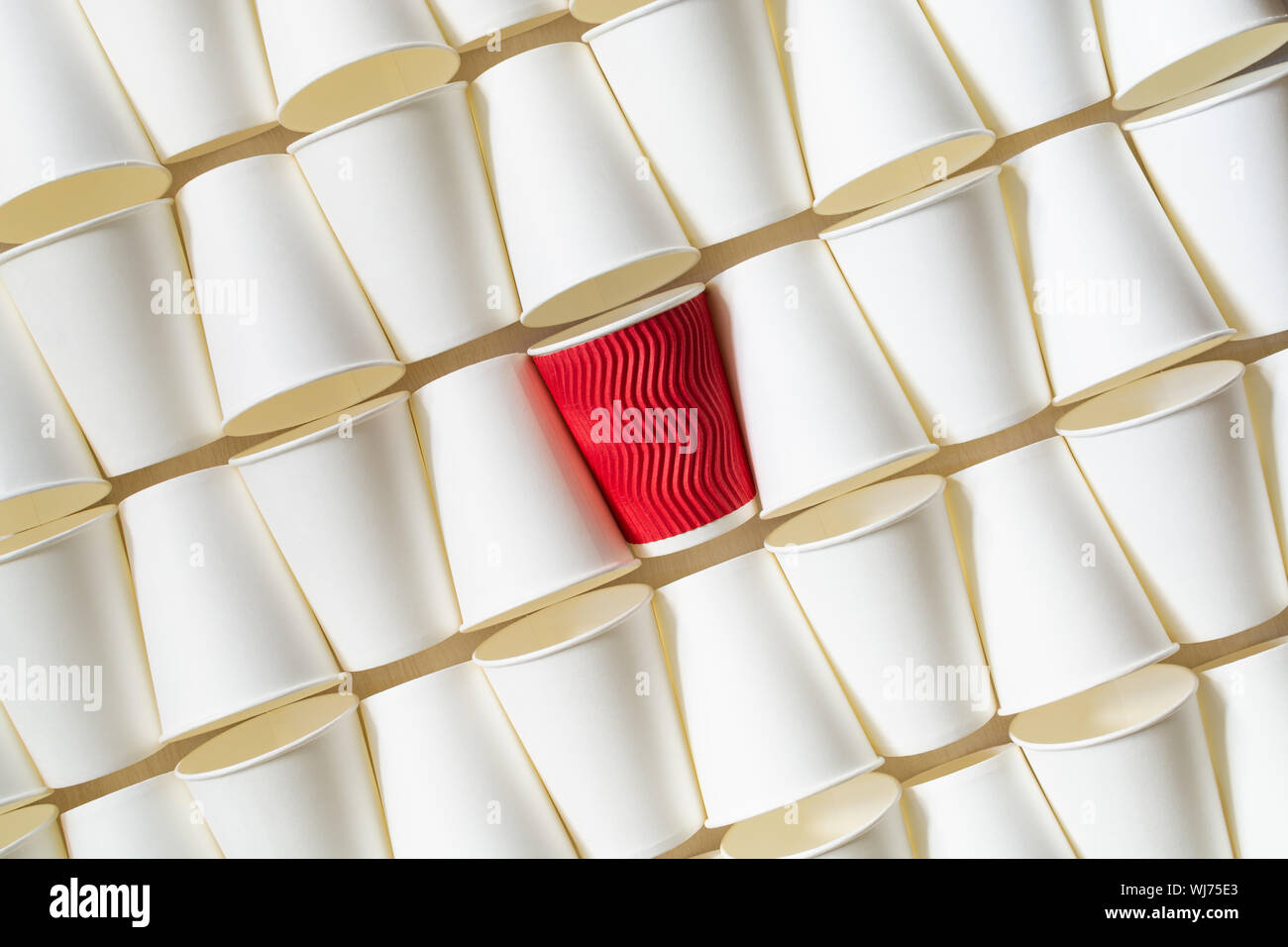 La configurazione di sfondo bianco di caffè bicchieri di carta con red cup in piedi fuori in mezzo. Orientamento diagonale, spazio di copia Foto Stock
