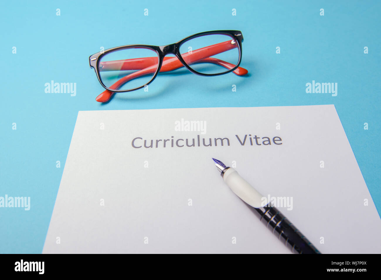 Curriculum vitae scritto su un vuoto di carta bianca su sfondo blu Foto Stock