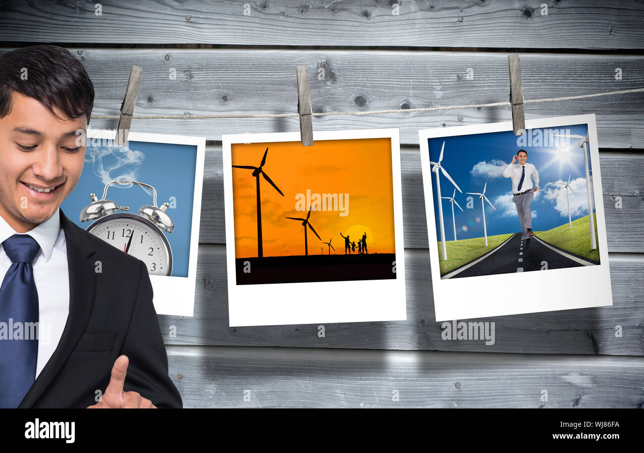 Immagine composita di imprenditore sorridente holding e puntamento Foto Stock