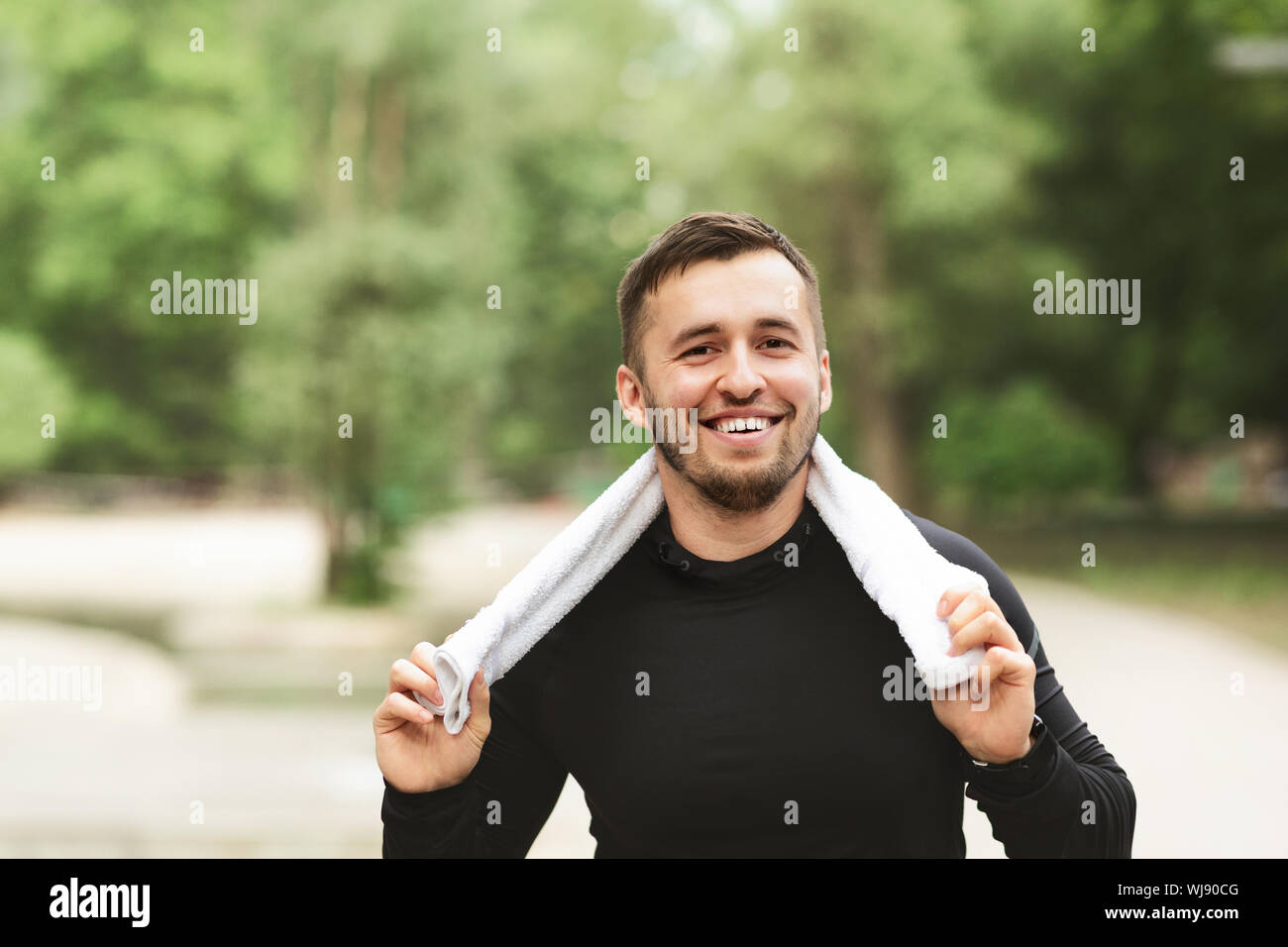 Ritratto di bel giovane atleta con asciugamano intorno al suo collo Foto Stock