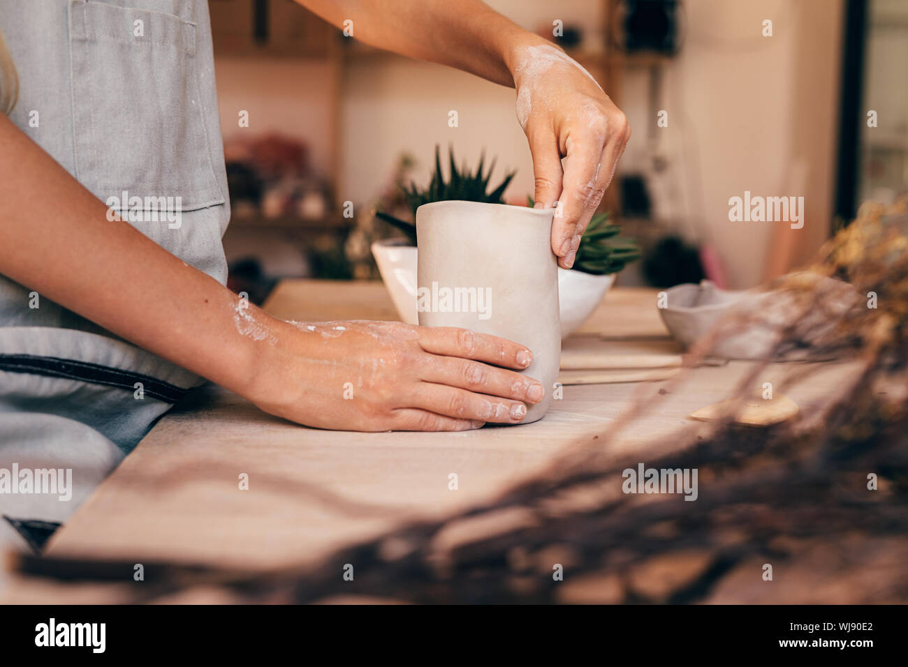 Le mani di una donna potter facendo una tazza di argilla. Craftswoman creta con le mani. Foto Stock