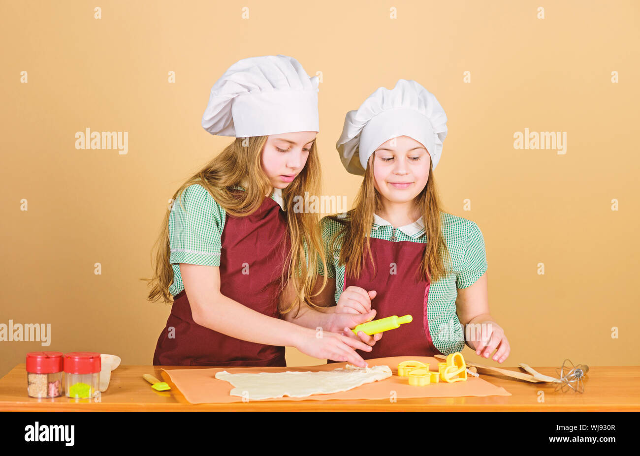 La pasticceria è di essere cotti al forno. Figlioli pasta di laminazione  per la casa cibo cotto. Le piccole bambine preparazione sfornati in cucina.  Un sapore di pane fresco Foto stock -