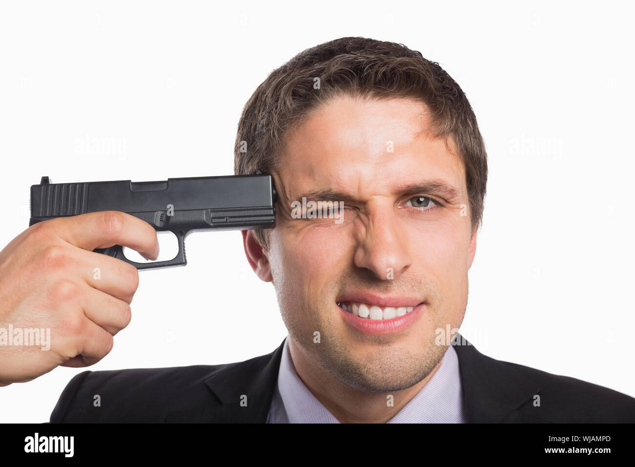 Close-up di un imprenditore in possesso di una pistola alla testa Foto Stock
