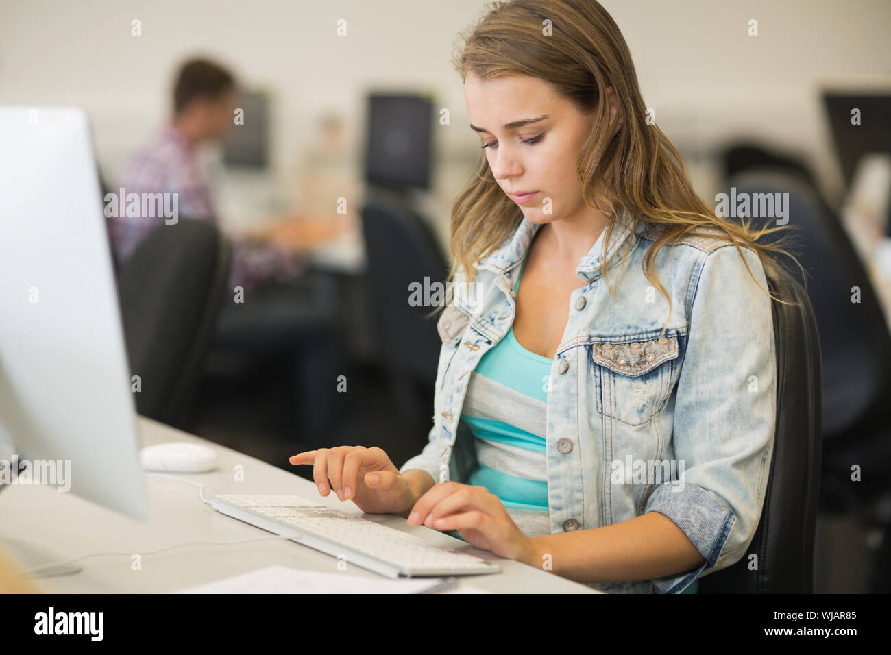 Focalizzato studente in sala computer Foto Stock