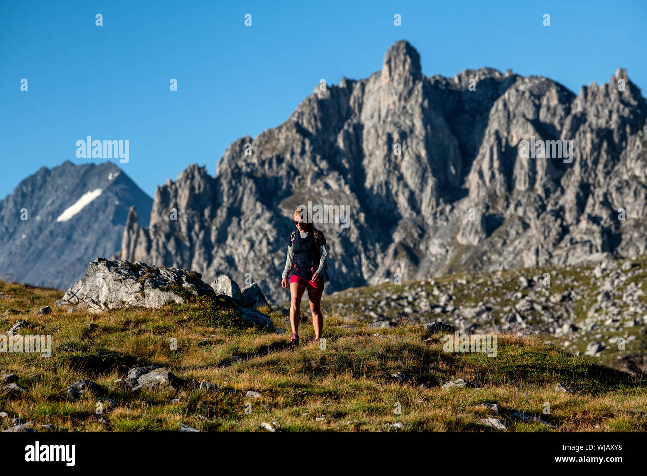 Una donna escursionista che cammina nel Parco Nazionale della Vanoise nella regione dell'Alvernia-Rhône-Alpes nel sud-est della Francia durante l'estate. Foto Stock