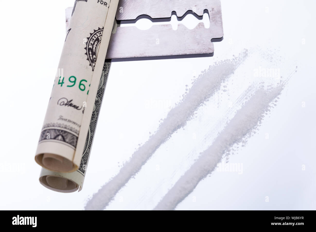 Linee di cocaina sullo specchio con una lama di rasoio farmaci oggetti  macro closeup Foto stock - Alamy