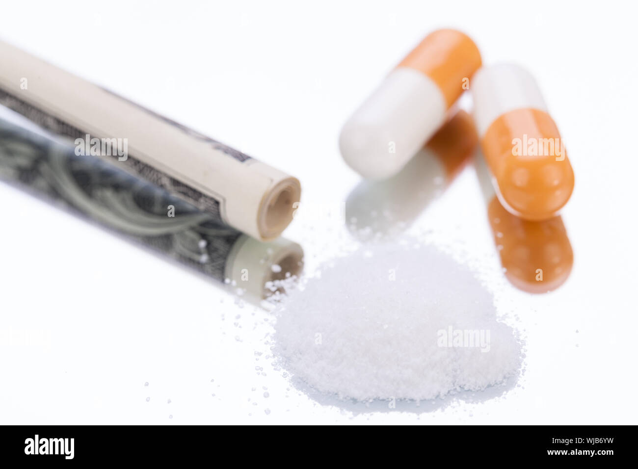 Illegale di pillole farmaceutiche e farmaci soldi su specchio oggetti dipendenza Foto Stock