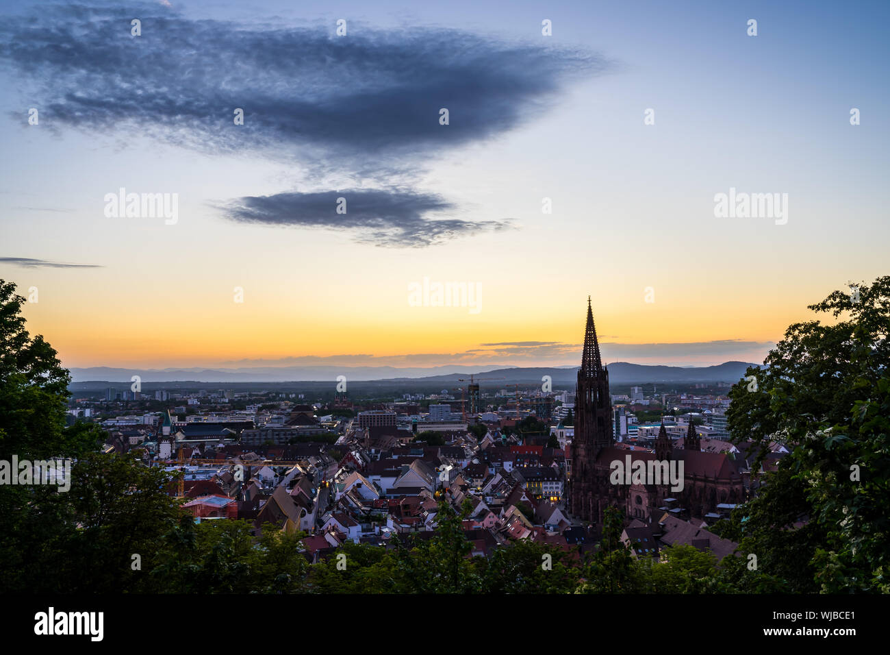 Germania, bella città Freiburg im Breisgau in arancione calda atmosfera del tramonto visto da sopra in estate Foto Stock