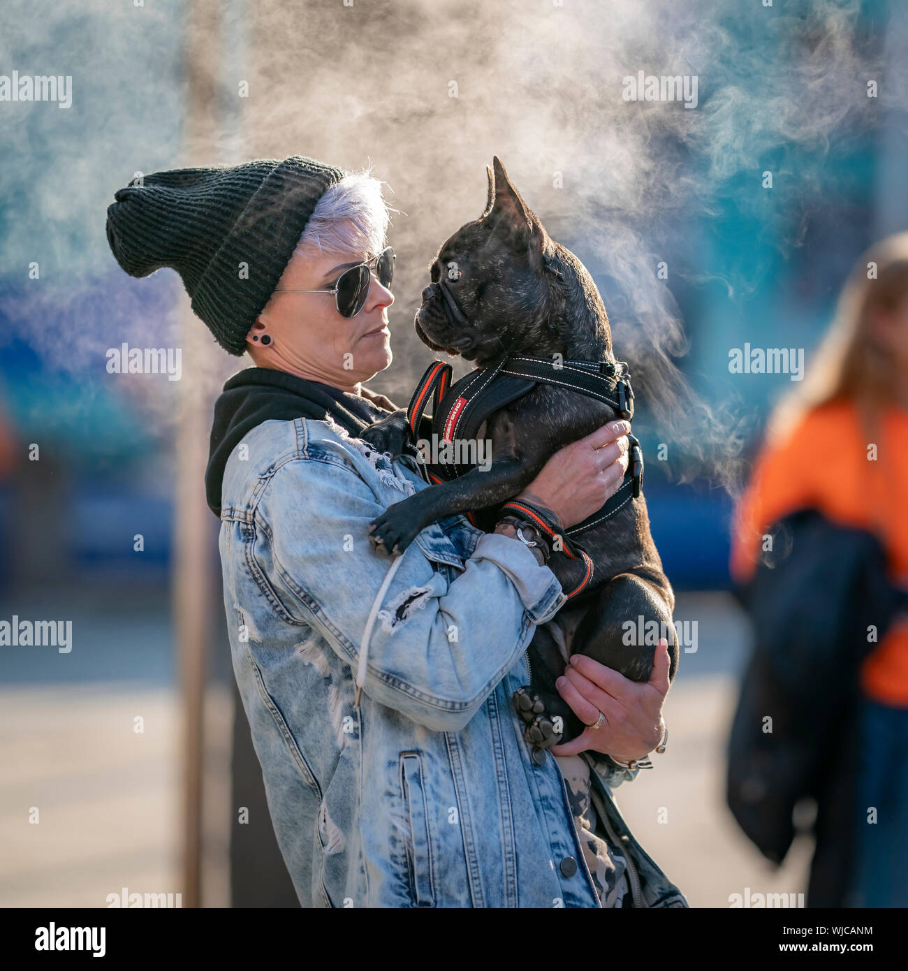 Donna che mantiene un bulldog francese, vapore in background, Menningarnott o Culturale giorno, Reykjavik, Islanda. Foto Stock