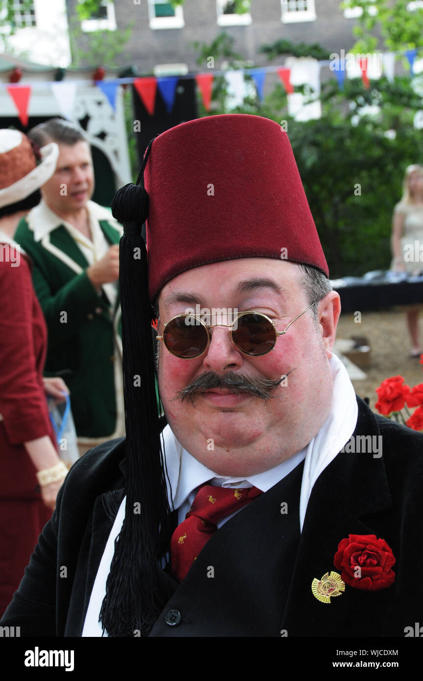 Un eccentrico uomo indossa un Fez, a Londra Summer evento sociale. Foto Stock