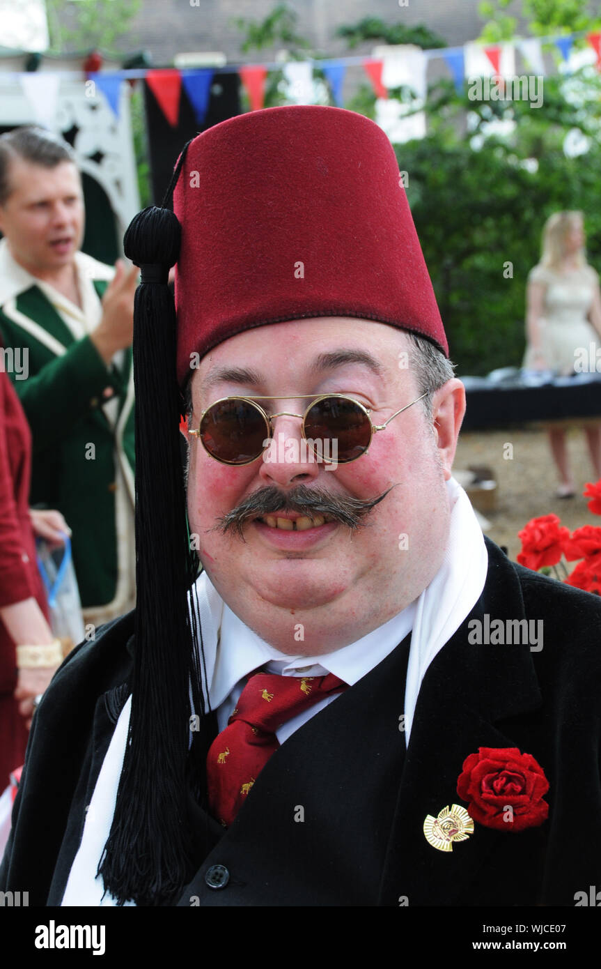 Un eccentrico uomo indossa un Fez, a Londra Summer evento sociale. Foto Stock