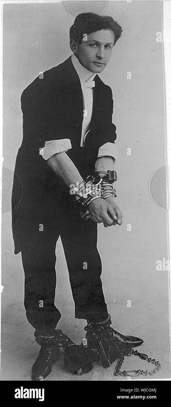 Harry Houdini, ritratto a figura intera, in piedi, rivolto verso destra in catene Foto Stock