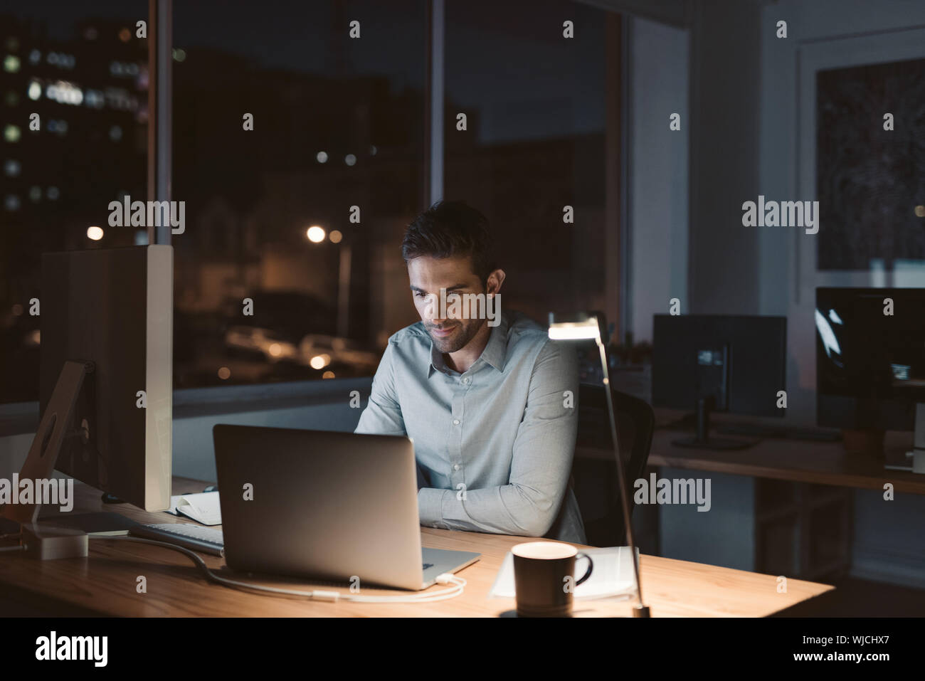 Giovane imprenditore a lavorare fino a tarda notte in un ufficio Foto Stock