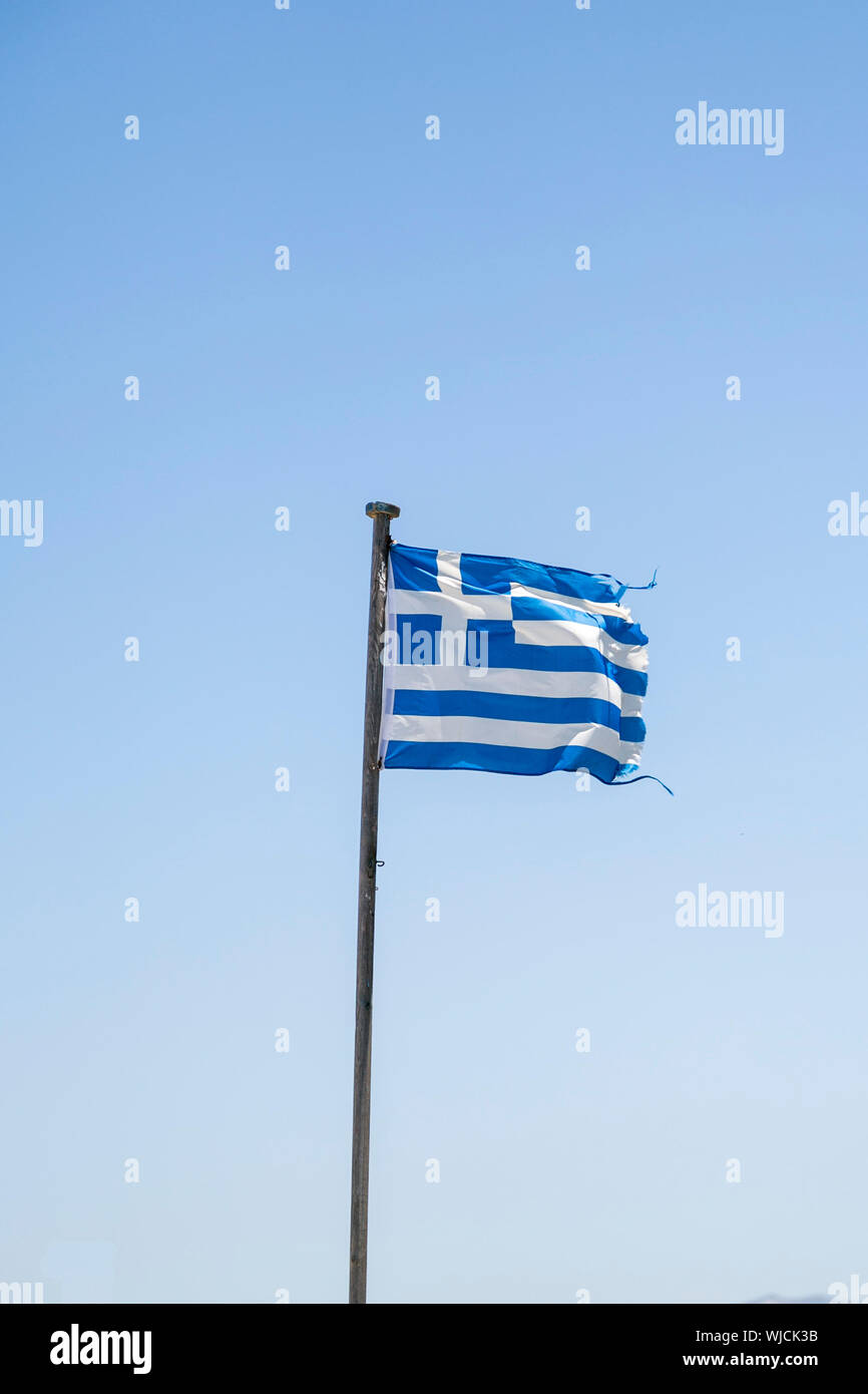 Old ragged bandiera greca, isolato sul cielo blu Foto Stock