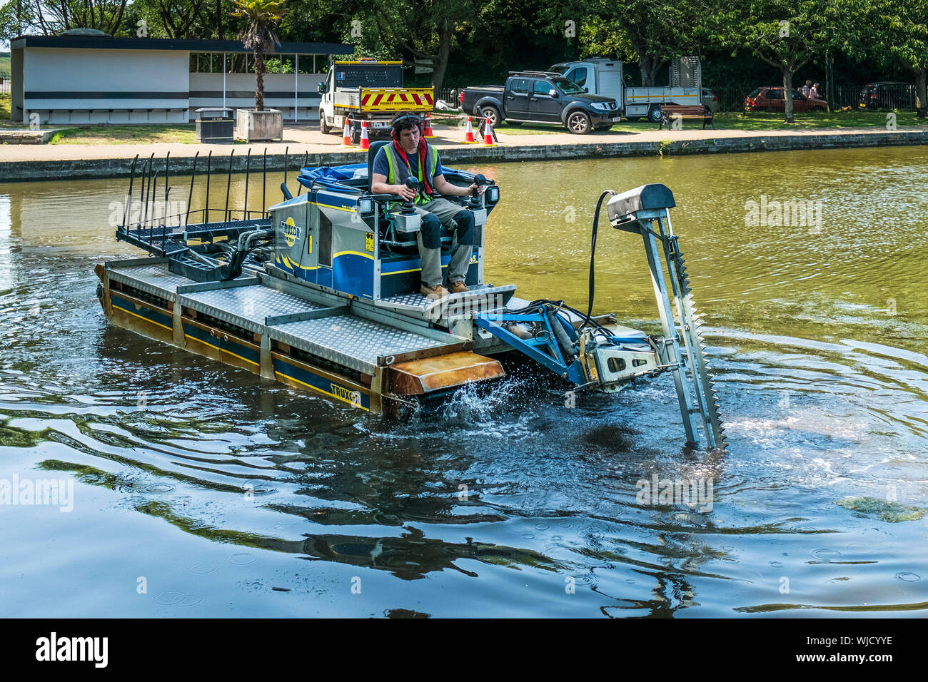 Un Truxor DM 5045 semovente toolcarrier anfibio lavorando al controllo di vegetazione invasiva in Trenance lago in barca a Newquay in Cornovaglia. Foto Stock