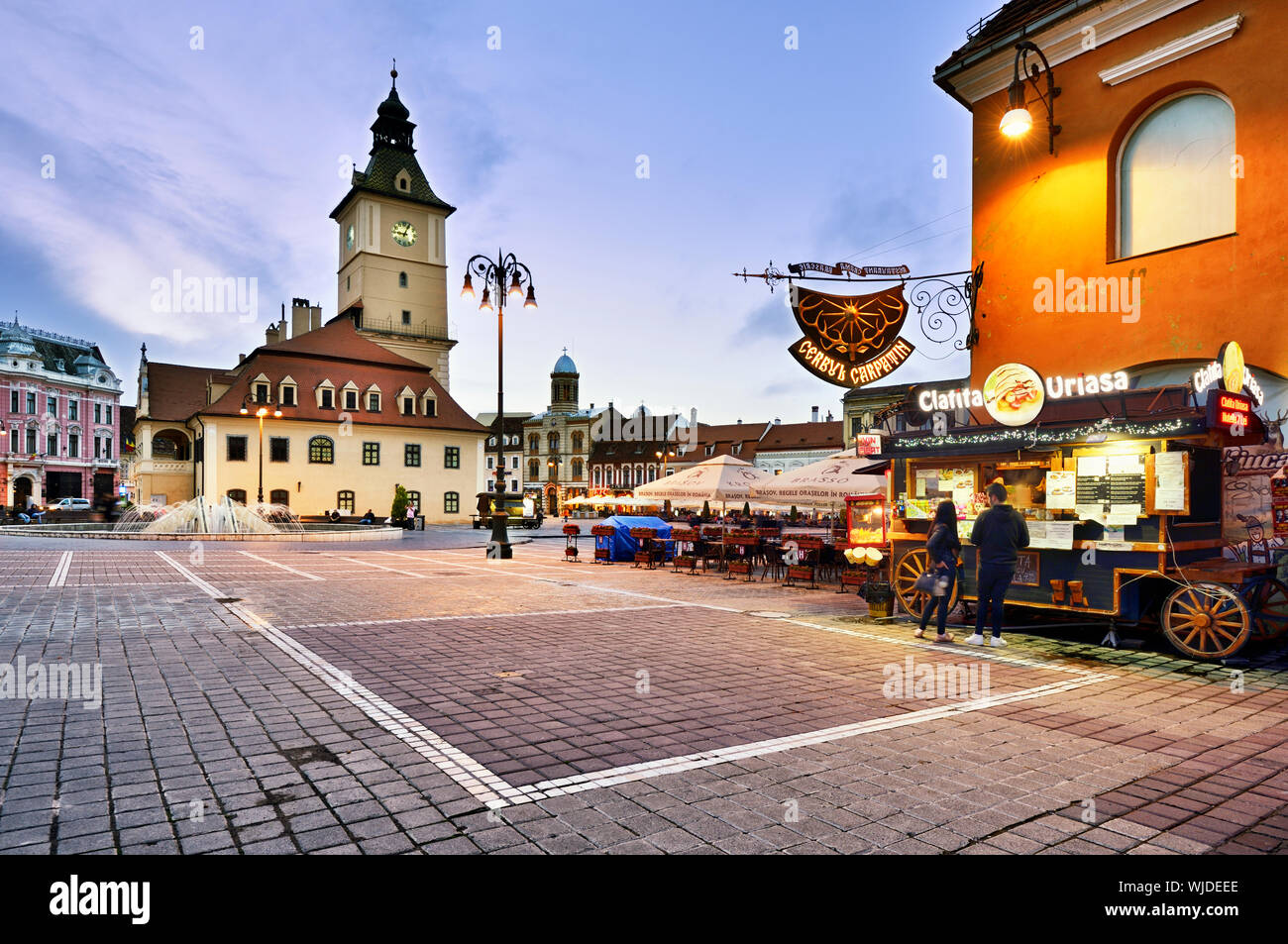 Piata Sfatului (Piazza del Consiglio) al tramonto, con l'ex casa Consiglio, costruito nel 1420, nel mezzo. Brasov, in Transilvania. La Romania Foto Stock