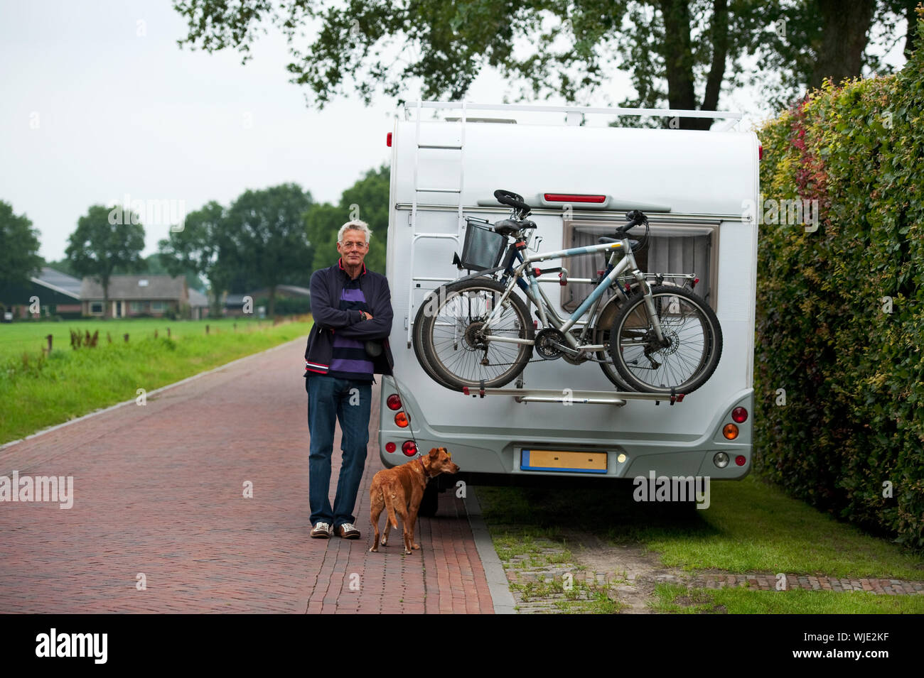 Un uomo con il suo camper orgoglioso di avere Foto Stock