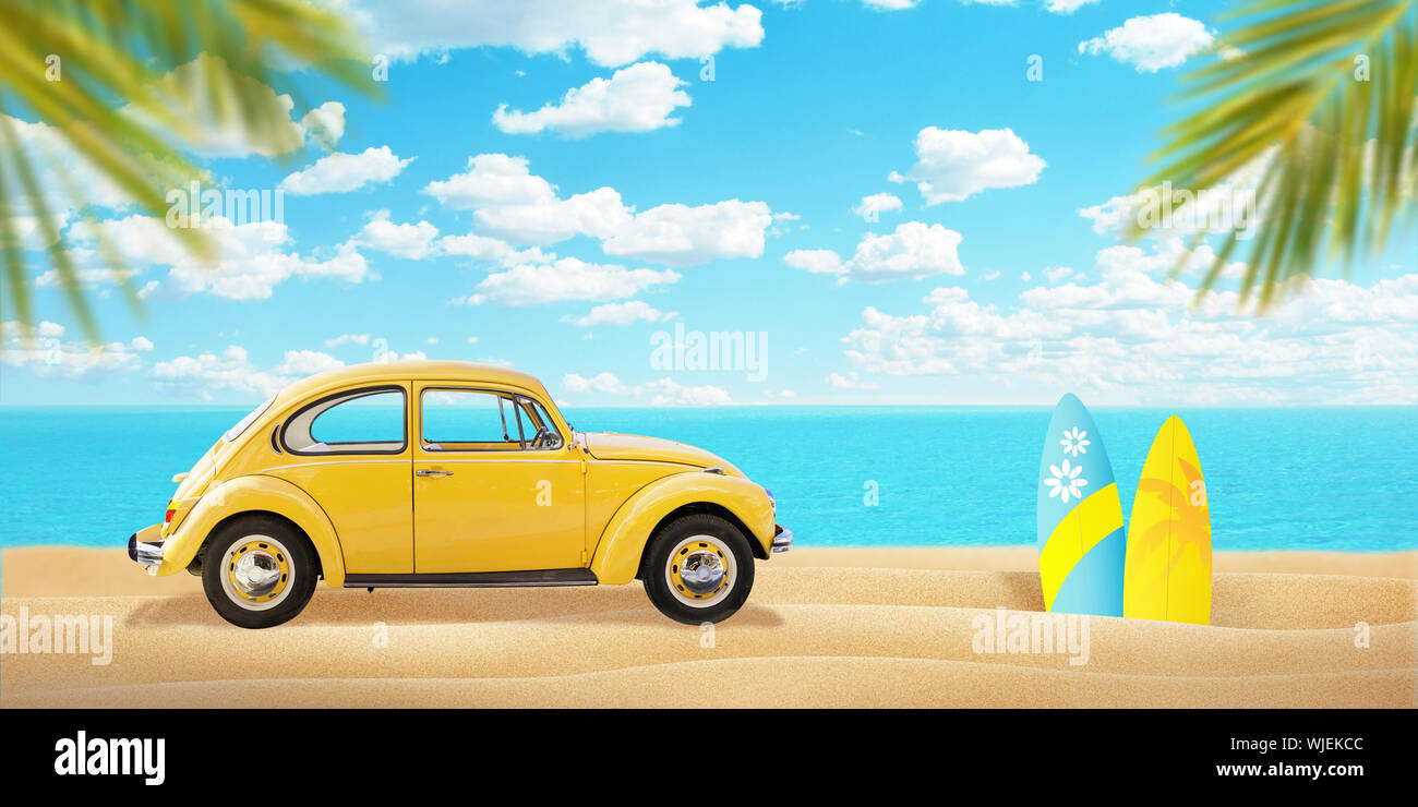 Giallo auto sulla spiaggia. Tavole da surf accanto e palme. Mare in background. Foto Stock