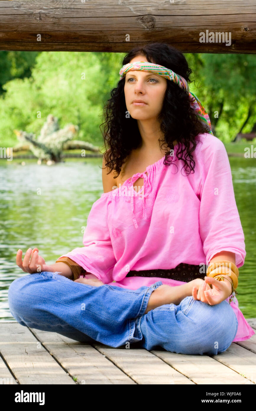Fotografia di una bella donna hippie meditando sul fiume beach Foto Stock