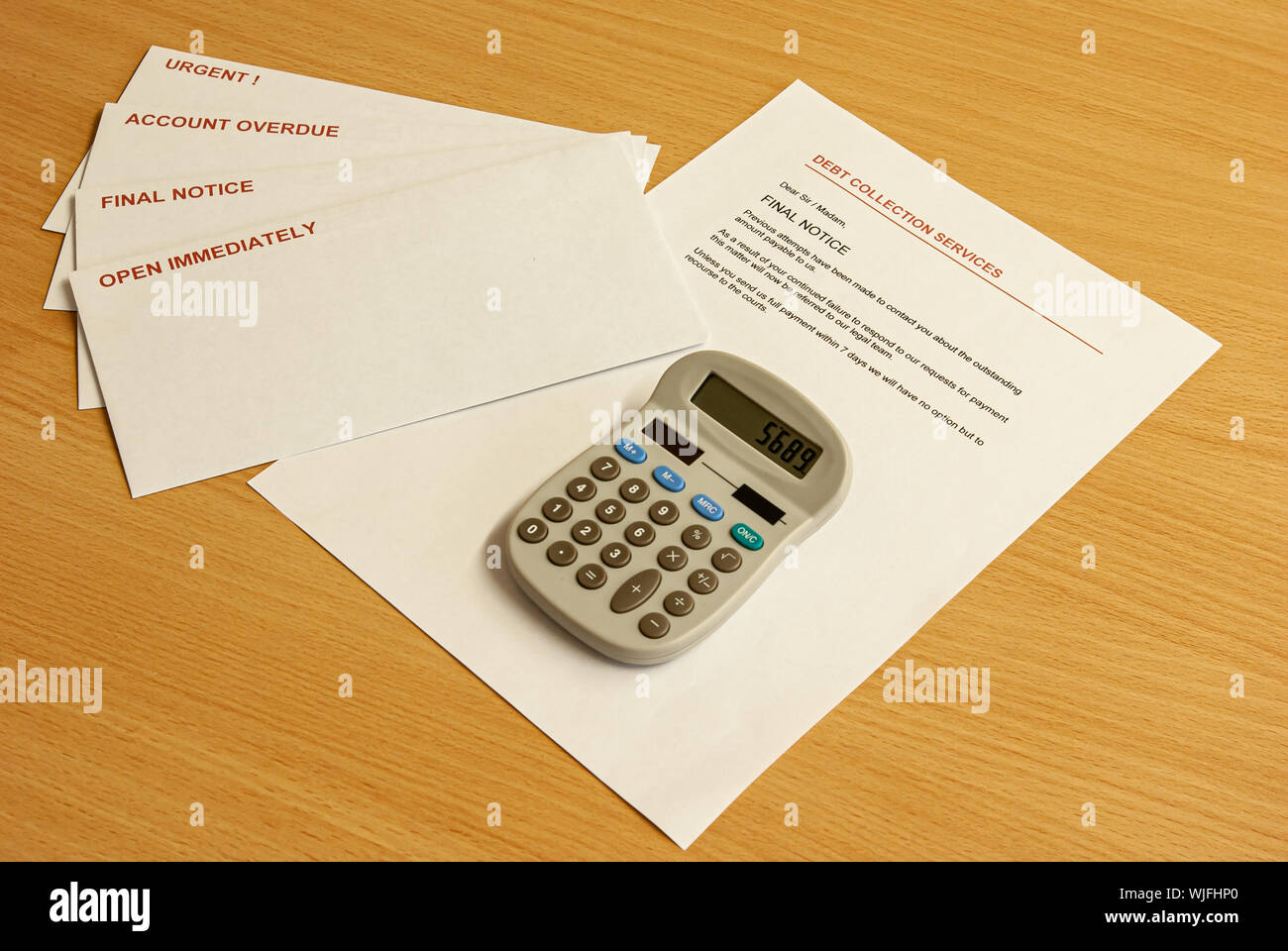 Lettere urgenti in buste con una lettera aperta e una calcolatrice su un  desktop di faggio Foto stock - Alamy