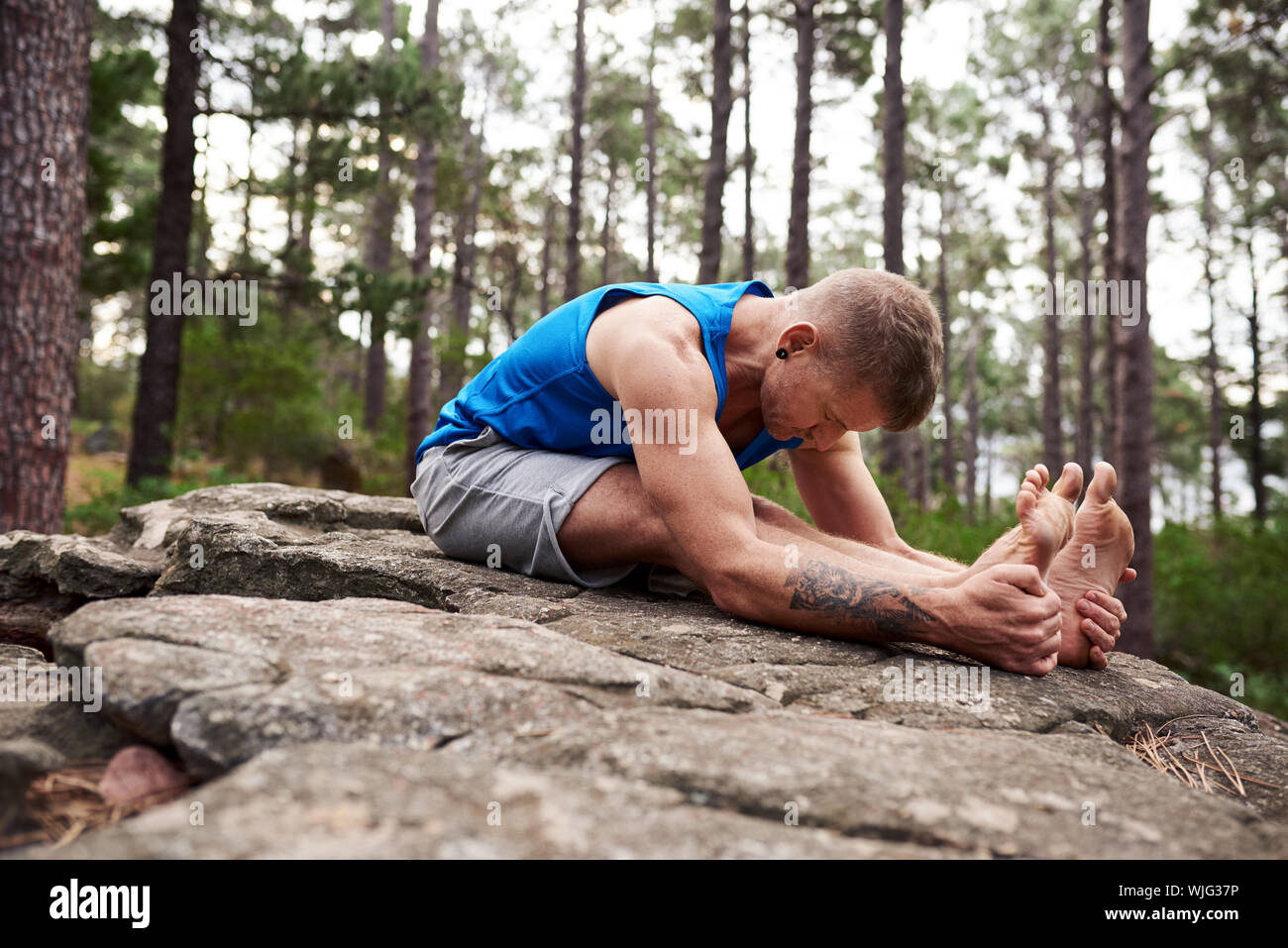 L'uomo facendo il tratto posteriore pongono in una foresta Foto Stock