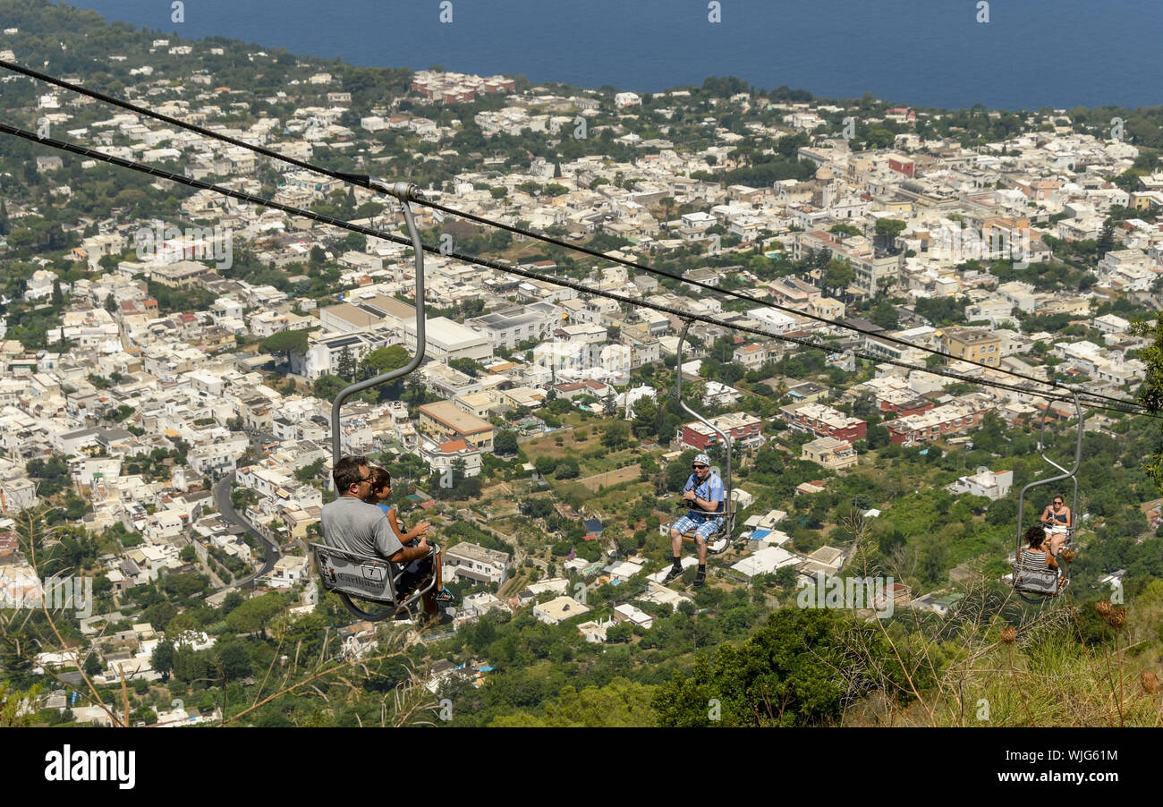 ANACAPRI ISOLA DI CAPRI, Italia - Agosto 2019: persone su una seggiovia che viaggiano su e giù per la montagna fino alla vetta del Monte Solaro al di sopra di Anacapri Foto Stock