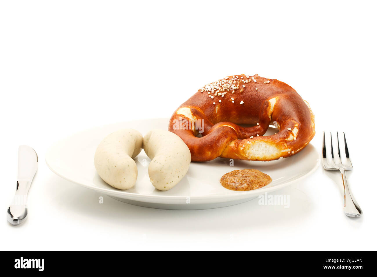 Bavarese di salsicce di vitello su una piastra con senape dolce e pretzel su sfondo bianco Foto Stock