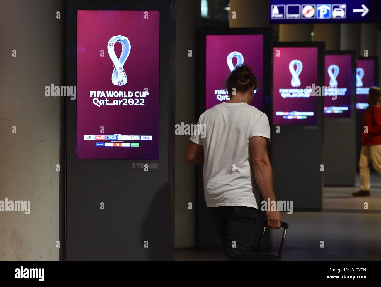 03 settembre 2019, Germania (tedesco), Berlino: il logo del 2022 FIFA World Cup in Qatar, pubblicato oggi, può essere visto sui tabelloni elettronici al piano terra della stazione ferroviaria principale. Essa è mostrata in modo alternato con altri messaggi pubblicitari. Il logo rappresenta stilizzata una ampia curva otto - simbolico delle otto World Cup negli stadi durante il round finale. Foto: Paolo Zinken/dpa Foto Stock