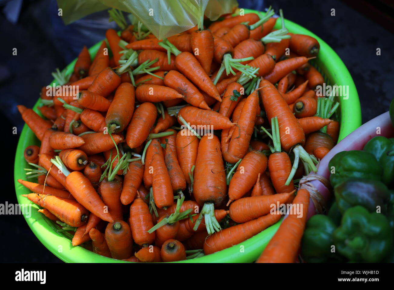Angolo di Alta Vista di carote e peperoni verdi per la vendita al mercato in stallo Foto Stock