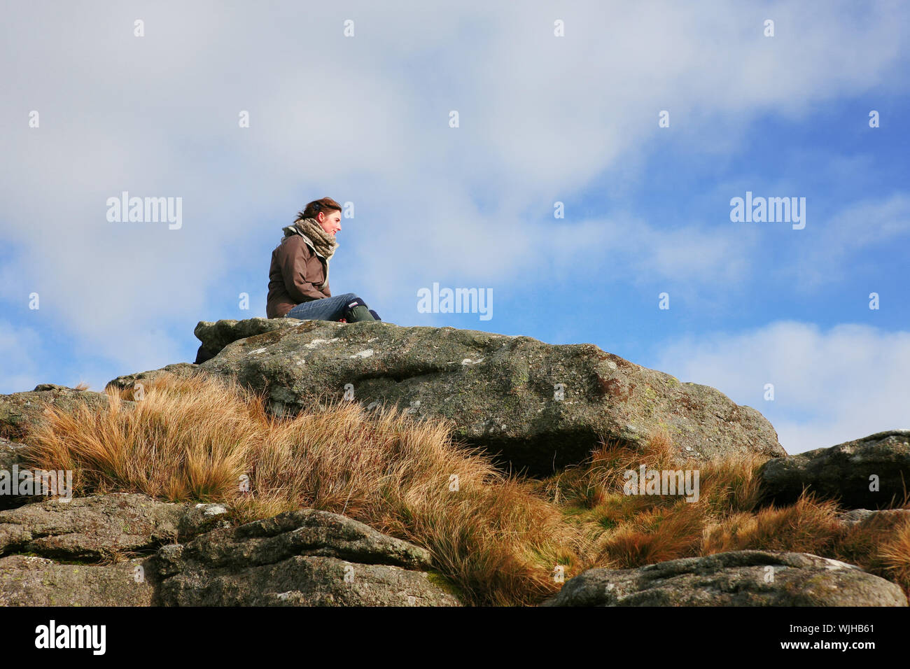 Giovane donna ammirando la vista dalla cima del Hound Tor, Dartmoor Devon, Regno Unito. Modello rilasciato Foto Stock
