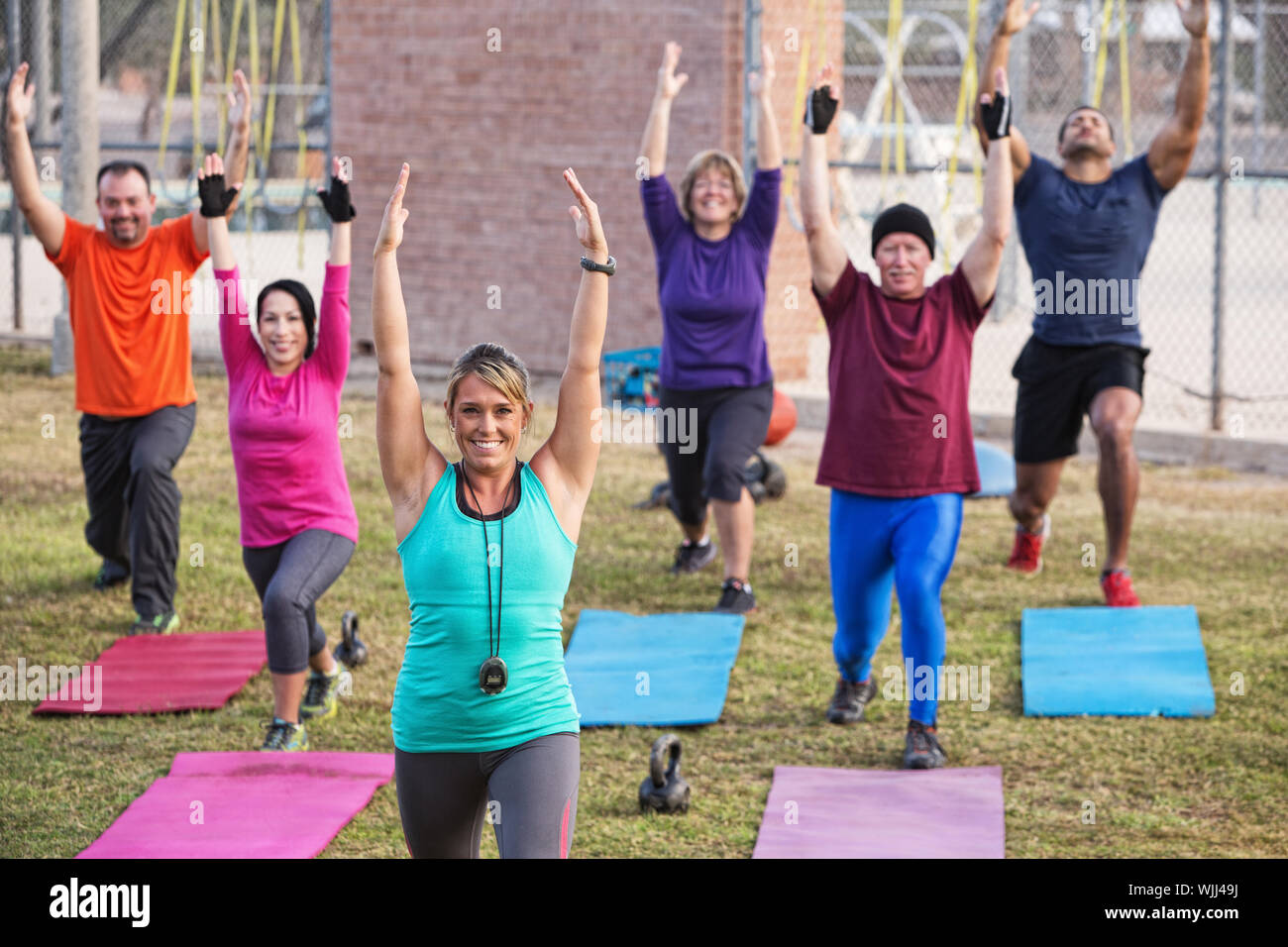 Gruppo di adulti attivi stretching all'aperto con stuoie Foto Stock