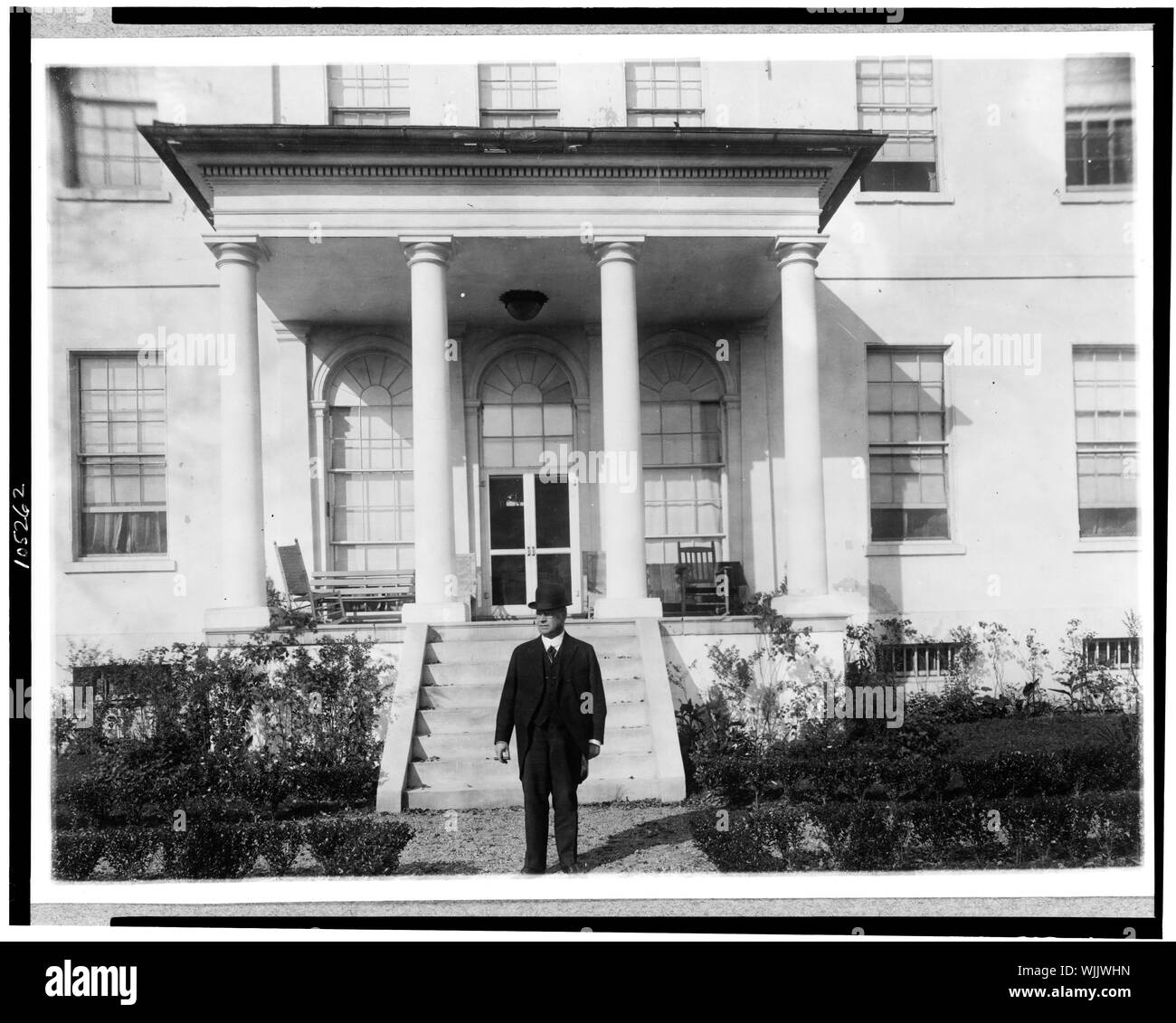 Hiram W. Johnson, ritratto a figura intera, in piedi al di fuori del palazzo, rivolto verso sinistra Foto Stock