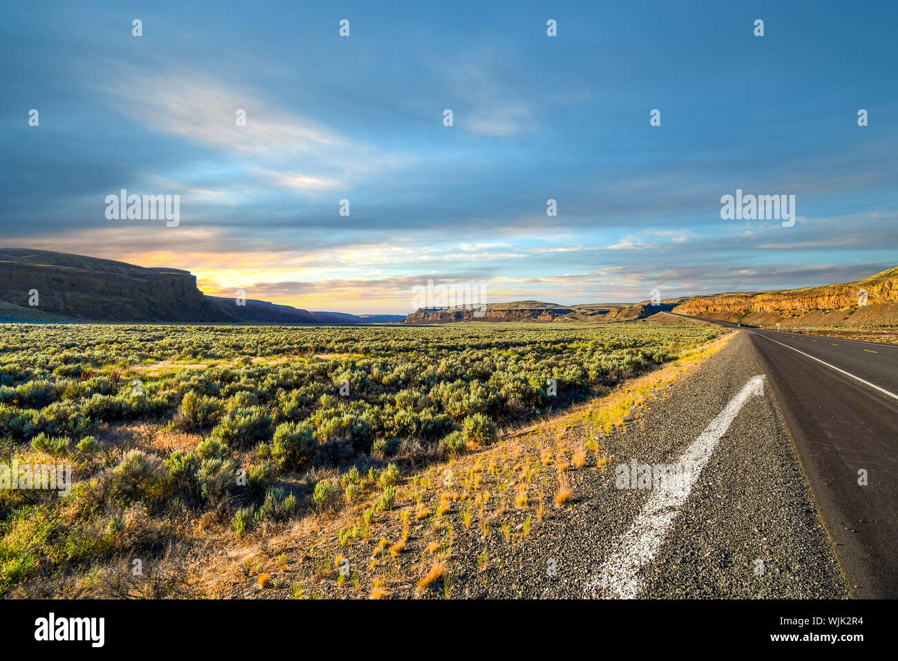 Lunga strada avvolgimento se il deserto piano terra spazzola nelle montagne dell'entroterra a nord-ovest di rurale dello stato di Washington nel deserto americano Foto Stock