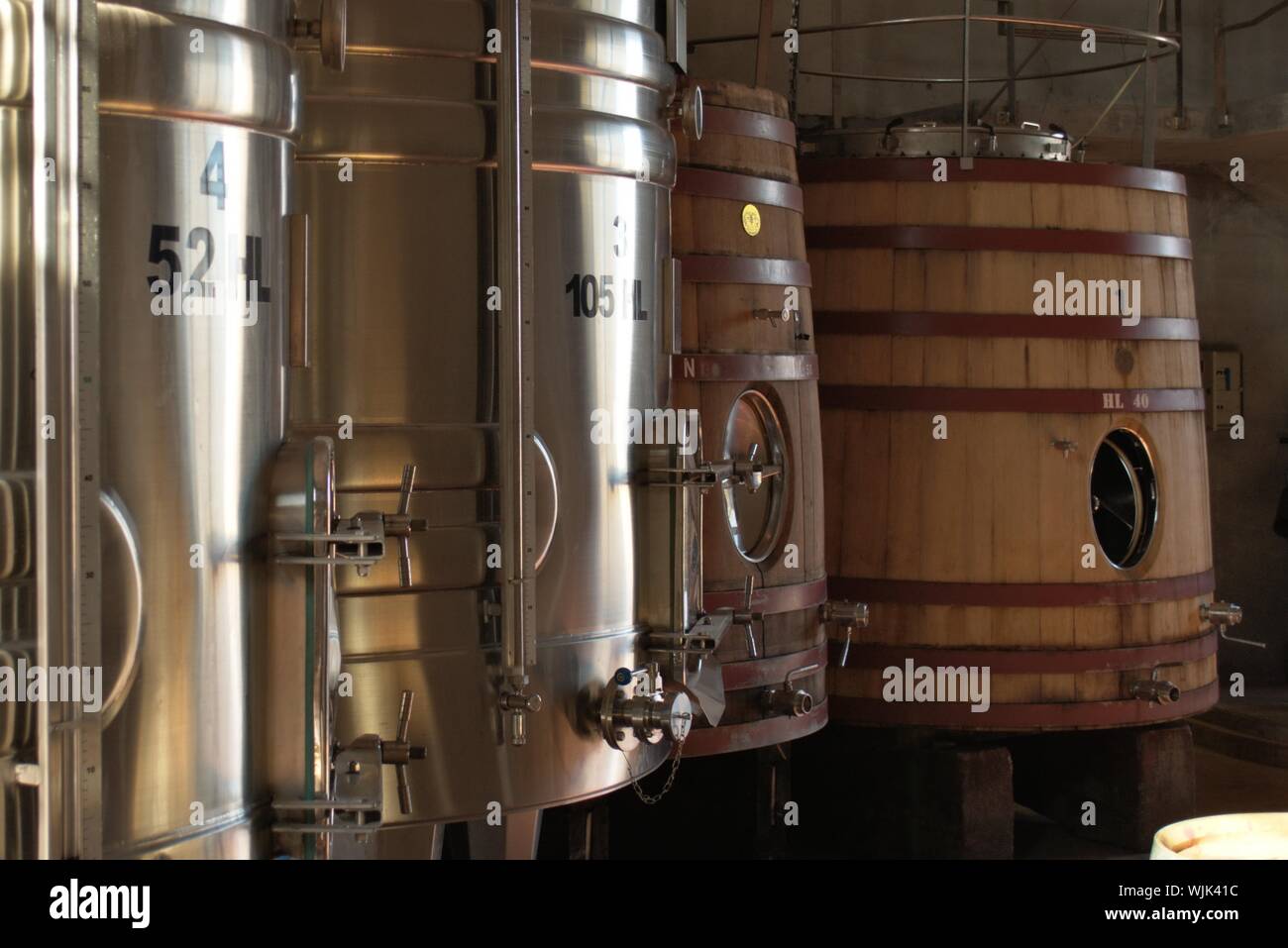 Serbatoi di vino in una cantina, alcuni fatti di acciaio inossidabile, gli altri due nel retro di legno. Foto Stock