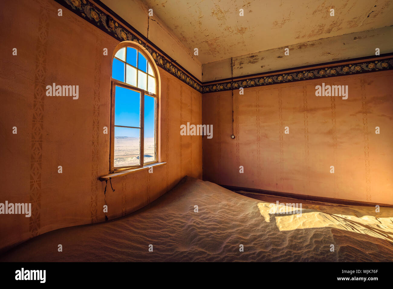 Stanza vuota con una finestra e la sabbia in le rovine di una città fantasma Kolmanskop, Namibia Foto Stock