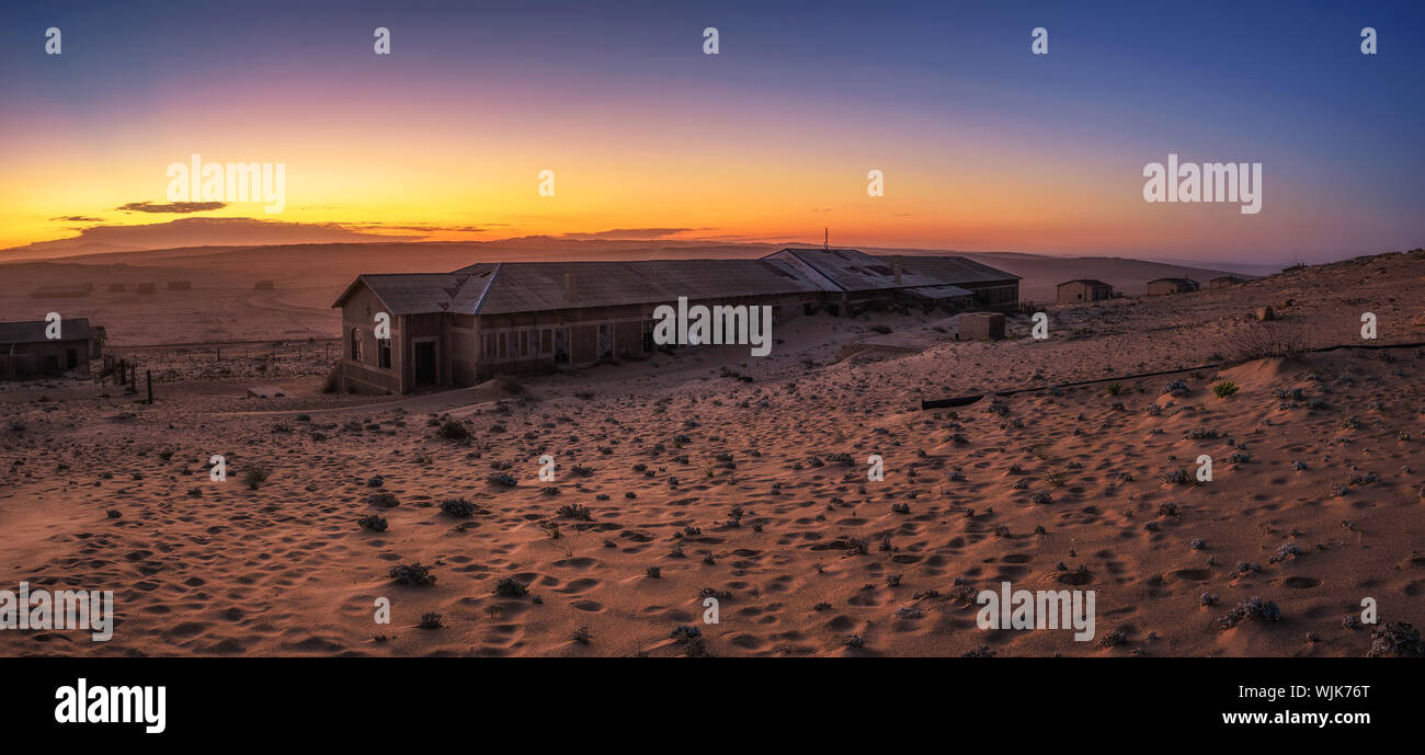 Sunrise sopra le case abbandonate di Kolmanskop città fantasma, Namibia. Foto Stock