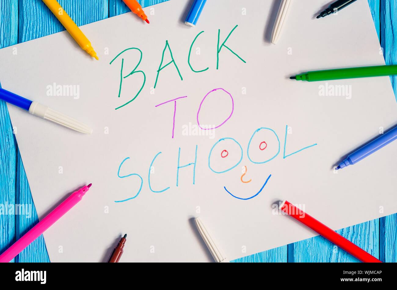 Idea creativa che raffigura il ritorno dei bambini a scuola. I marcatori di scuola e di una scheda con il testo torna a scuola. Foto Stock