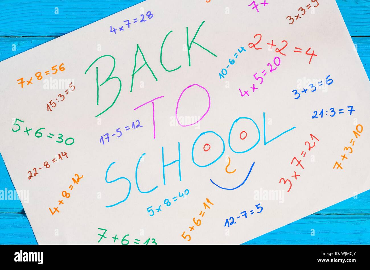 Idea creativa che raffigura il ritorno dei bambini a scuola. Carta bianca con operazioni matematiche e testo per tornare a scuola. Foto Stock