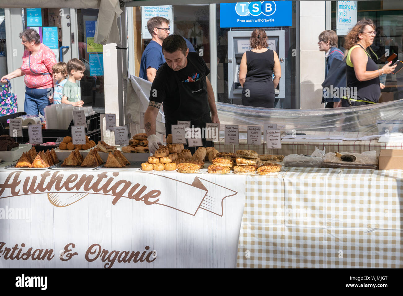 Winchester, Hampshire, Regno Unito un uomo pasticceria di vendita su un mercato in stallo Foto Stock