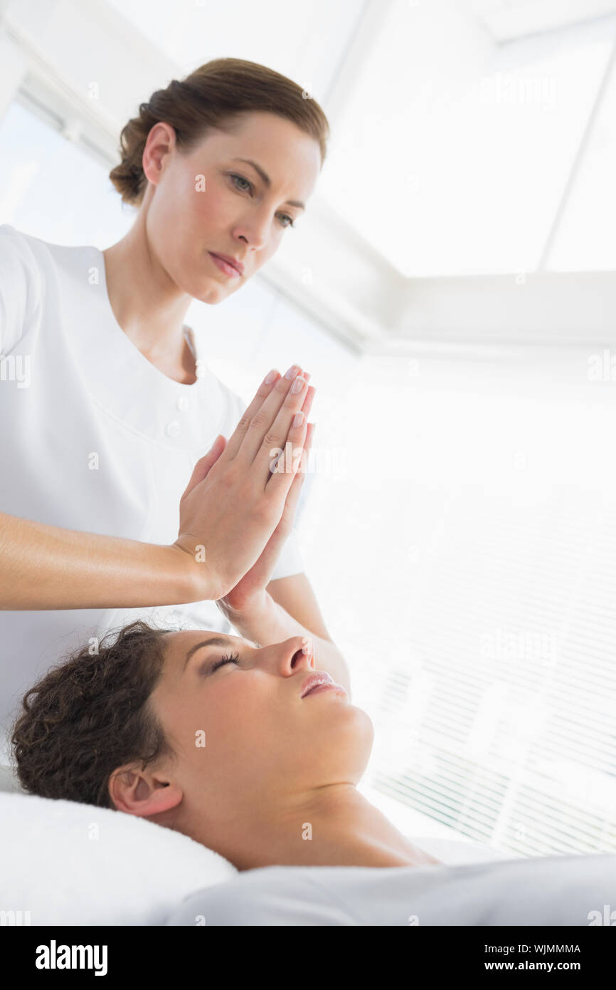 Terapista del sesso femminile dando trattamento Reiki per donna a health spa  Foto stock - Alamy